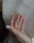 women's hand showing off a crystal charm pendant on a 14k gold chain necklace