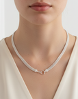 A frontal view of a female model wearing a foxtail mesh necklace with a circle clasp feature.