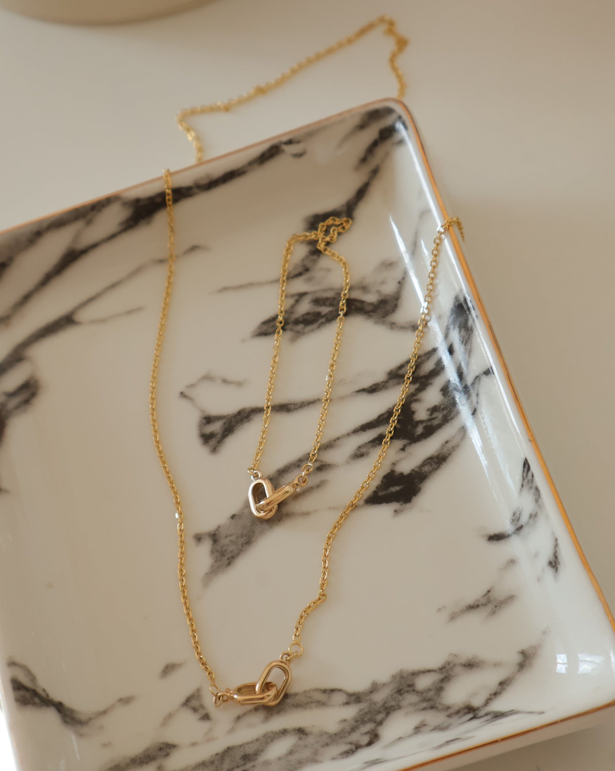 necklace and bracelet combo in 14k gold on a marble surface elegant arrangement
