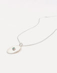 A sterling silver pendant with a round solitaire gemstone in the center, attached to a dainty, adjustable chain.
