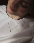 women wearing a dainty gold chain with a chrysoprase charm pendant