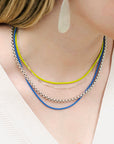 women wearing four sterling silver necklaces with two color coated chains and a heavy box chain