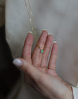 women's hand showing off a crystal charm pendant on a 14k gold chain necklace