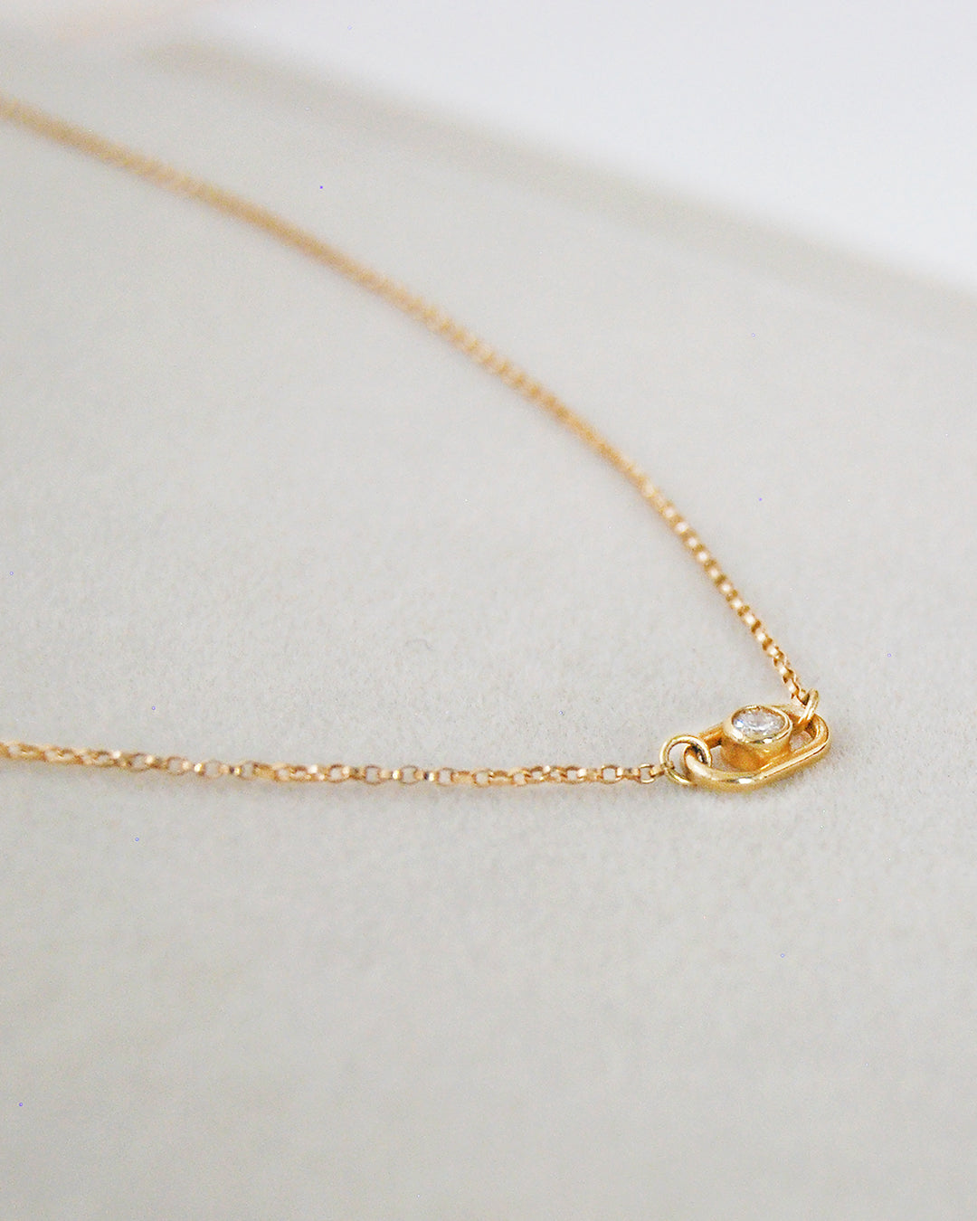 14k gold minimalist necklace featuring a lab-grown sustainable diamond, photographed in a soft neutral setting by Sincerely Chain Co.