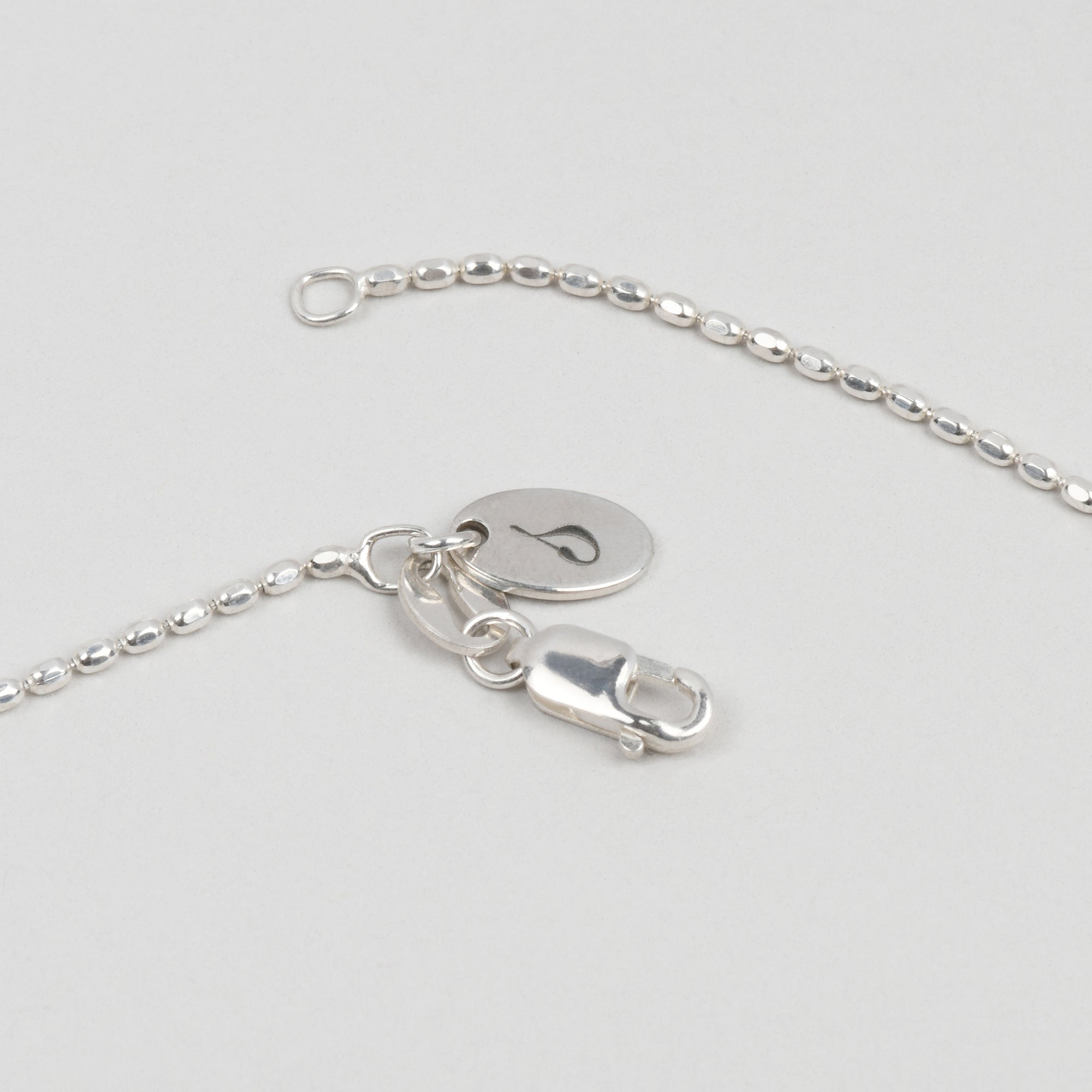 detail of sterling silver beaded necklace with sincerely chain co logo tag