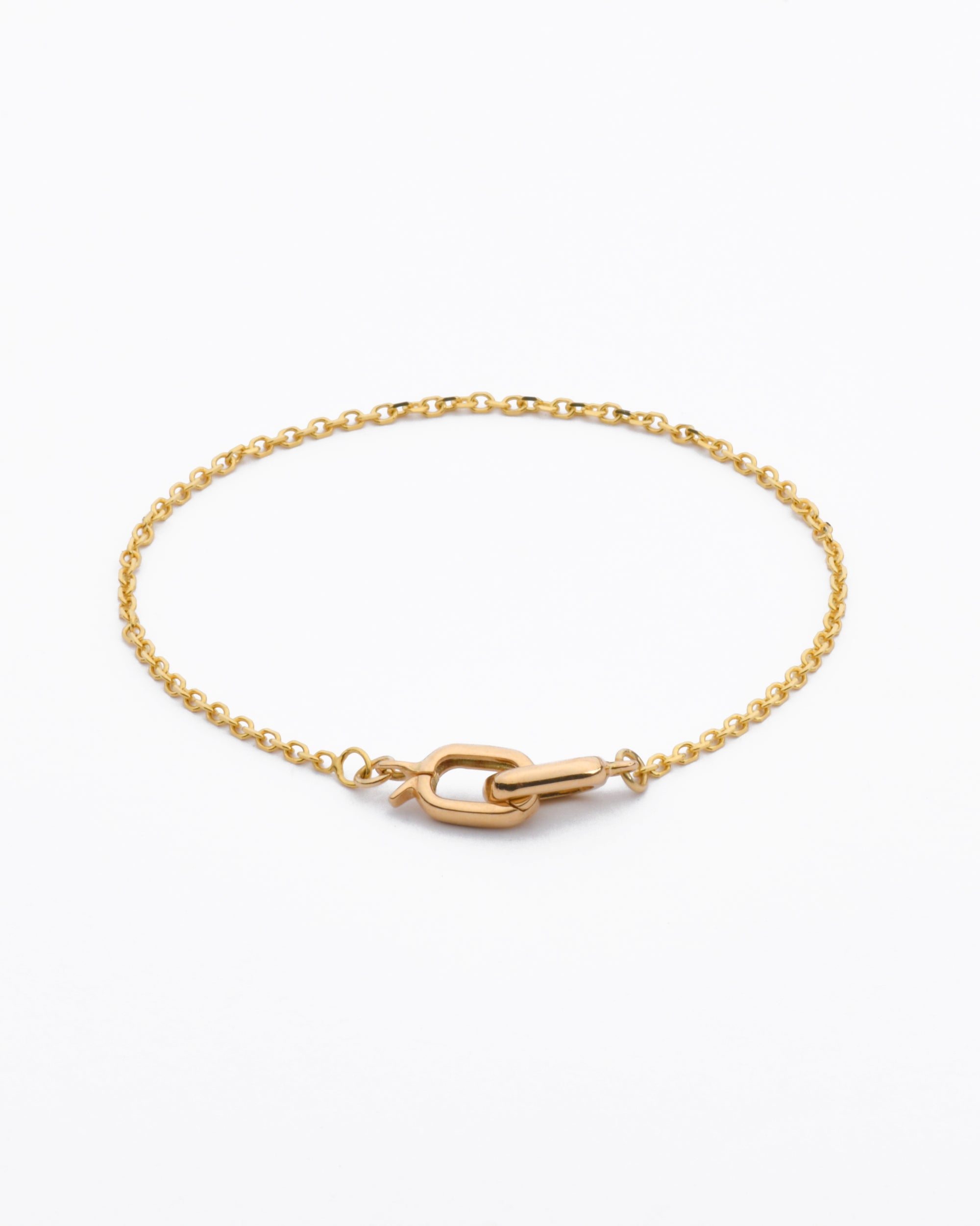 elegant 14 karat gold bracelet featuring a bevel cut cable chain and interlocking double oval clasp