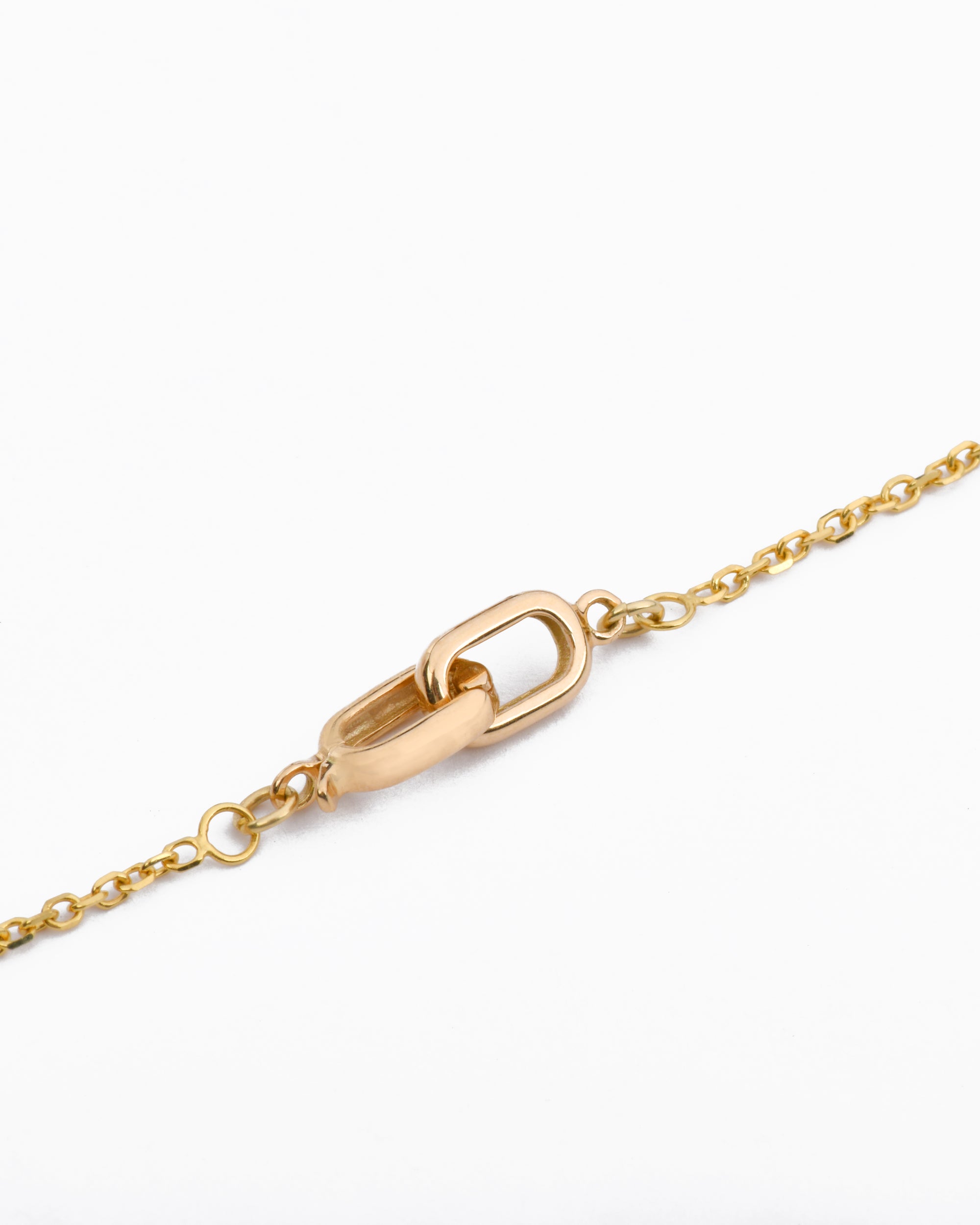 a featured gold clasp with two interlocking oval shapes on a gold necklace