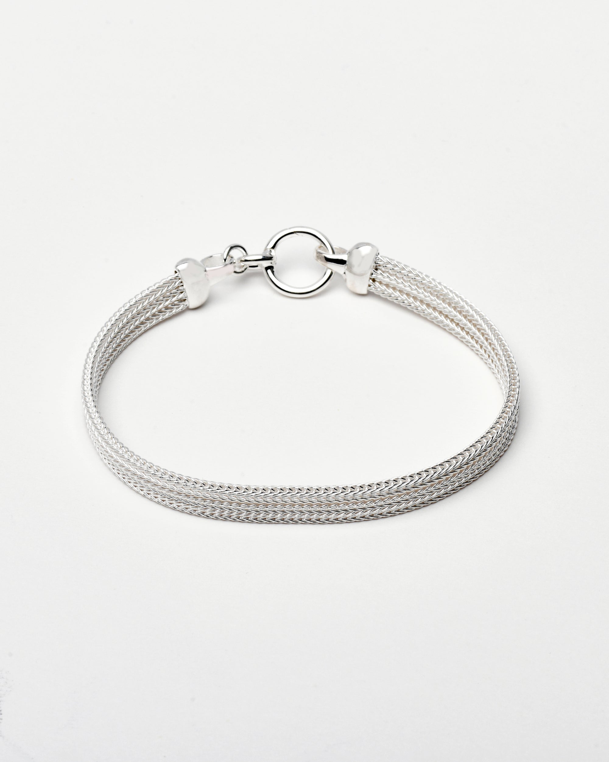 Sterling silver bracelet with a mesh style chain featuring a circular hinge clasp on a white background, by Sincerely Chain Co.