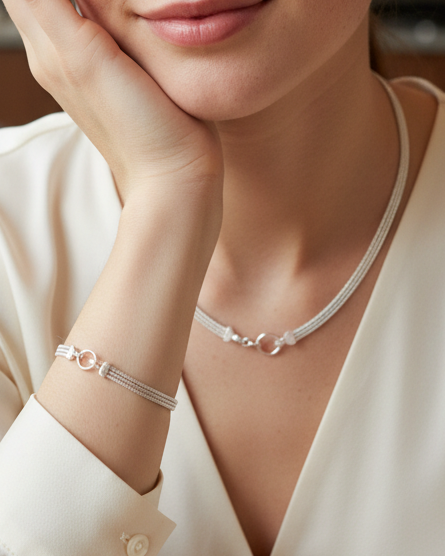 Women wearing a matching set necklace and bracelet in a fine mesh sterling silver with a featured circle hinge clasp.