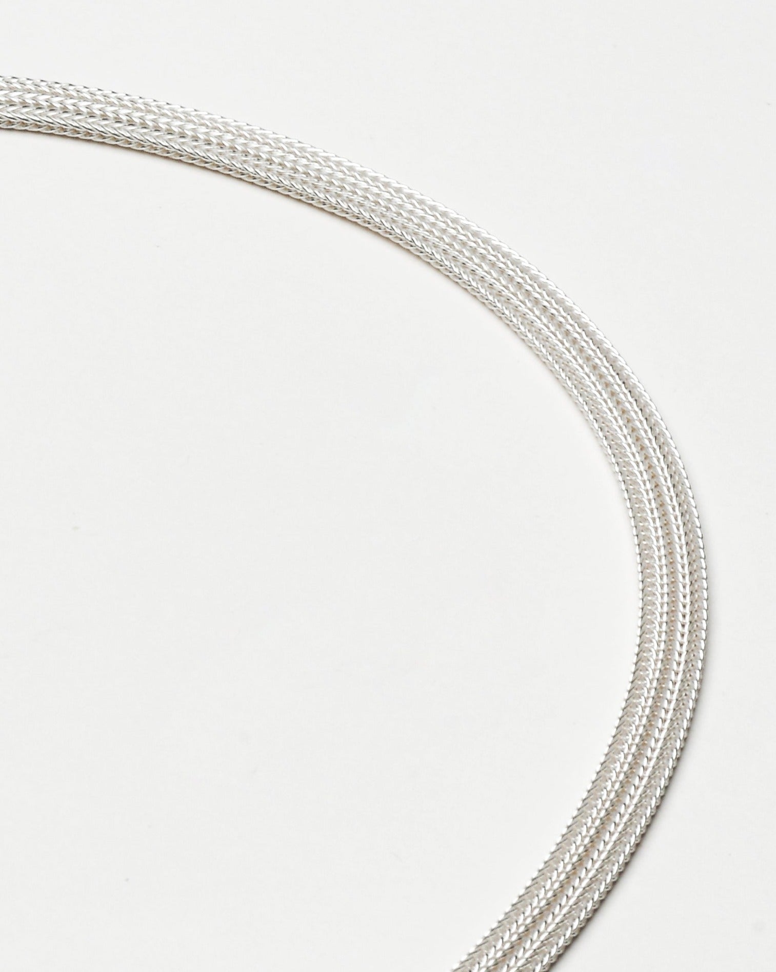 A closeup of a foxtail mesh necklace made from sterling silver.
