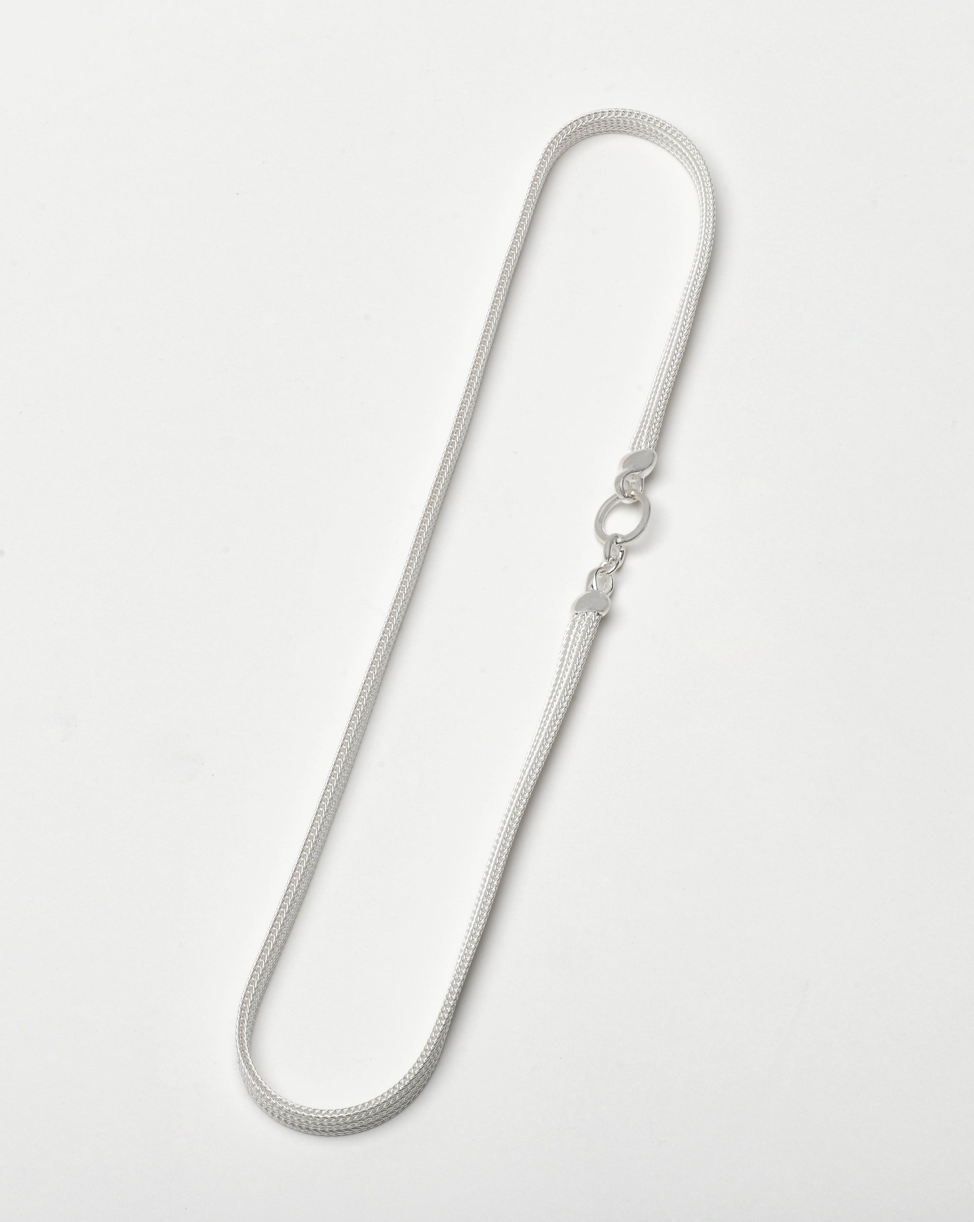 A foxtail mesh necklace laid out on a white background featuring design elements by Sincerely Chain Co. jewelry.