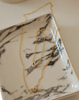 necklace and bracelet combo in 14k gold on a marble surface elegant arrangement