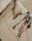 marble dish holding 14k gold bracelet and necklace set