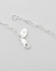 A sterling silver necklace with a delicate paperclip chain design and a branded lobster clasp closure, minimalist jewelry by Sincerely Chain Co.