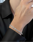 A business women wearing a sterling silver puffed anchor chain bracelet and a black blouse.