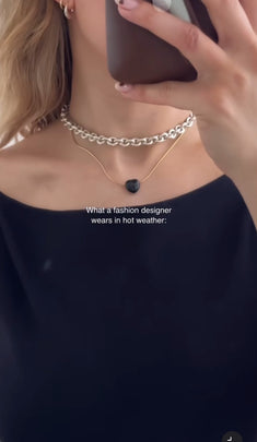 Person wearing necklaces with a dark top, text overlay about fashion design.