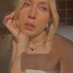 Woman with blonde hair and a sterling silver necklace by Sincerely Chain Co. in a bathroom