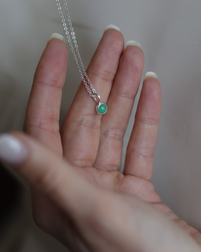 Hand holding charm necklace in sterling silver, minimalist jewelry by Sincerely Chain Co.