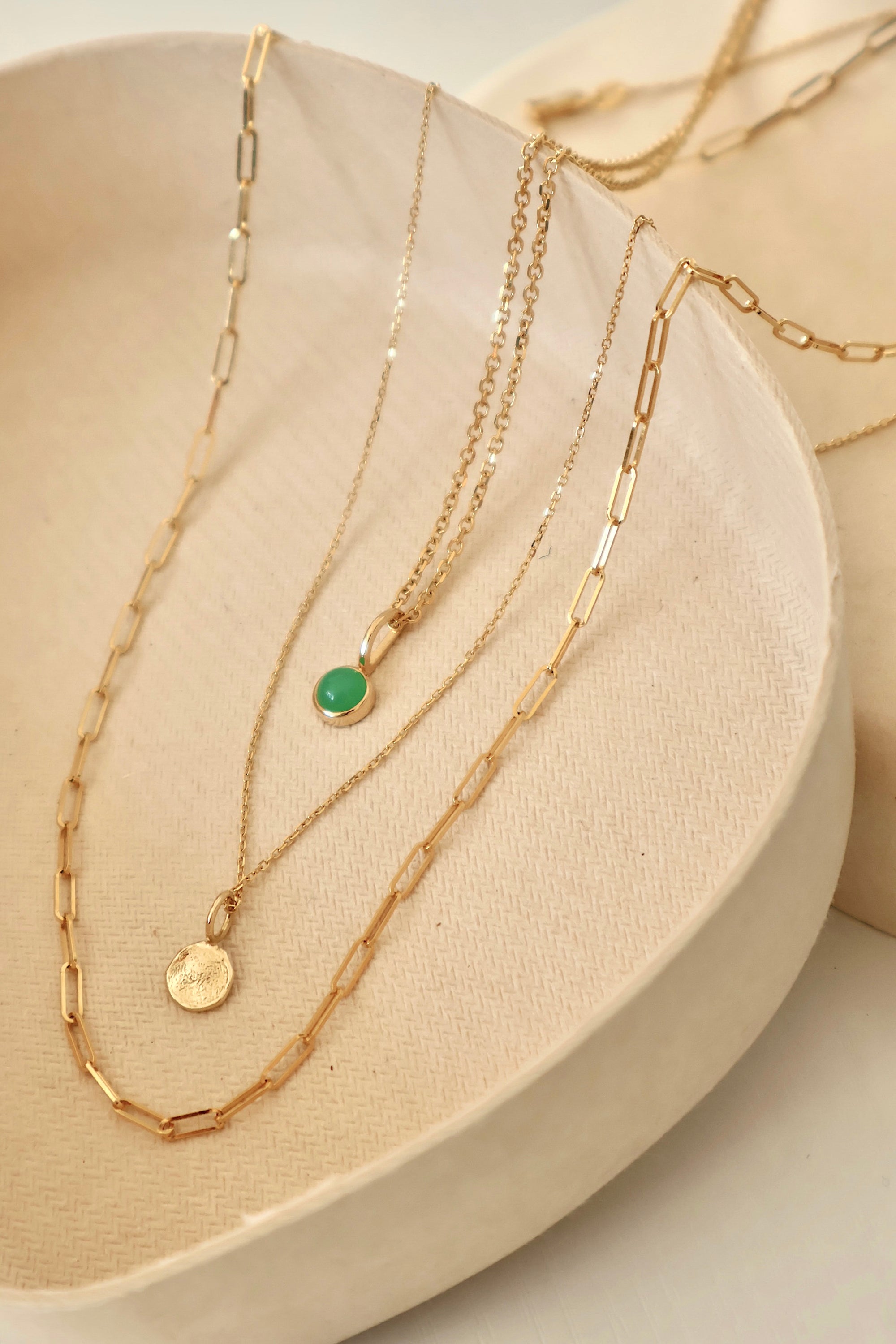 14k gold chain necklaces featuring two pendants displayed on a clay dish, modern minimalist jewelry by Sincerely Chain Co.