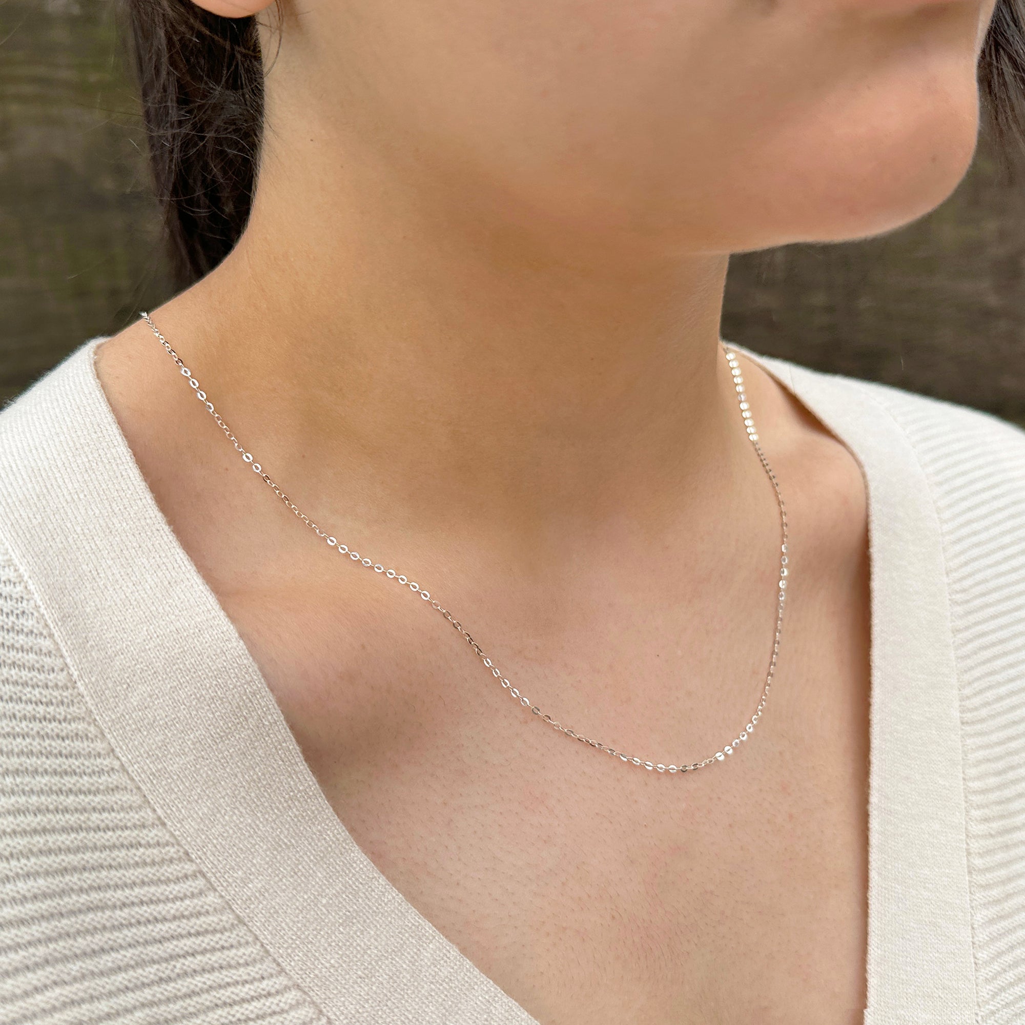women wearing a delicate sterling silver cable chain sparkling in the sun