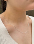 women wearing a delicate sterling silver cable chain sparkling in the sun