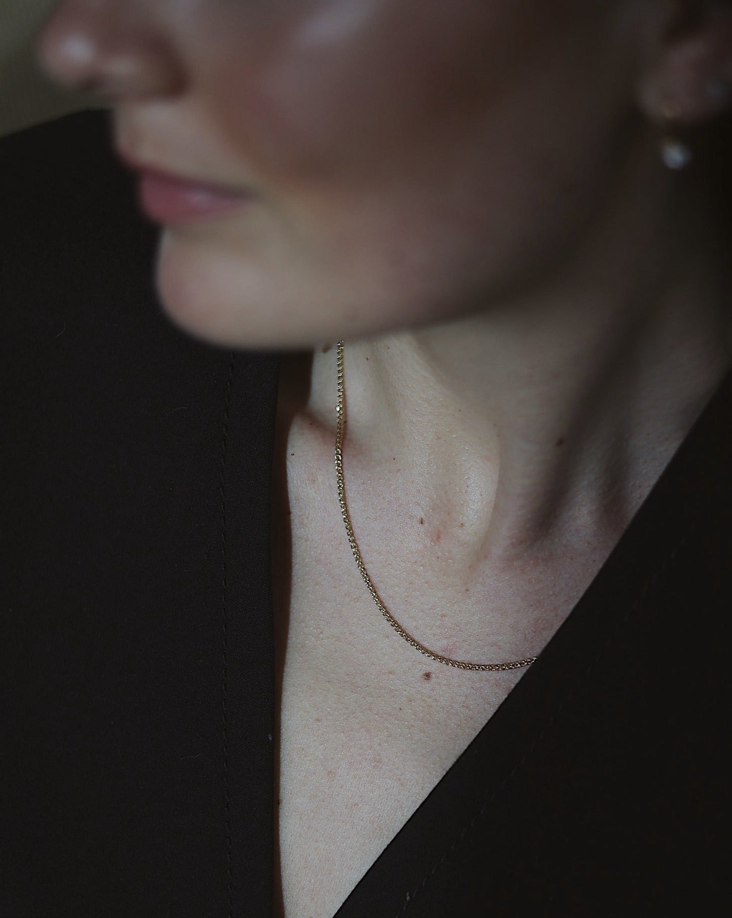 elegant women in black wearing a 14k gold chain necklace 