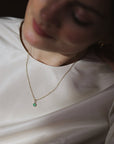 women wearing a dainty gold chain with a chrysoprase charm pendant 