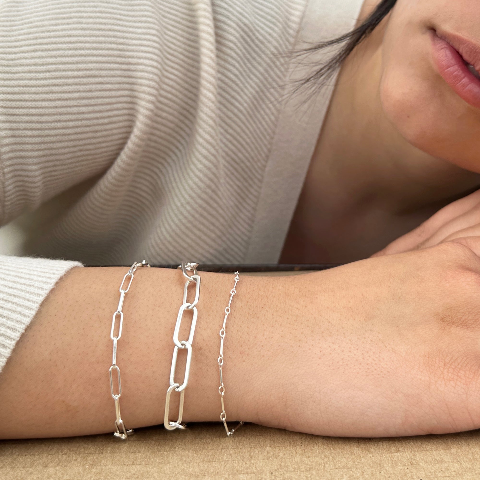 Women wearing a bracelet stack three sterling silver chains