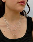 elegant women wearing a silver necklace stack with various chain styles 