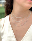 women wearing an elegant three necklace stack in sterling silver chains